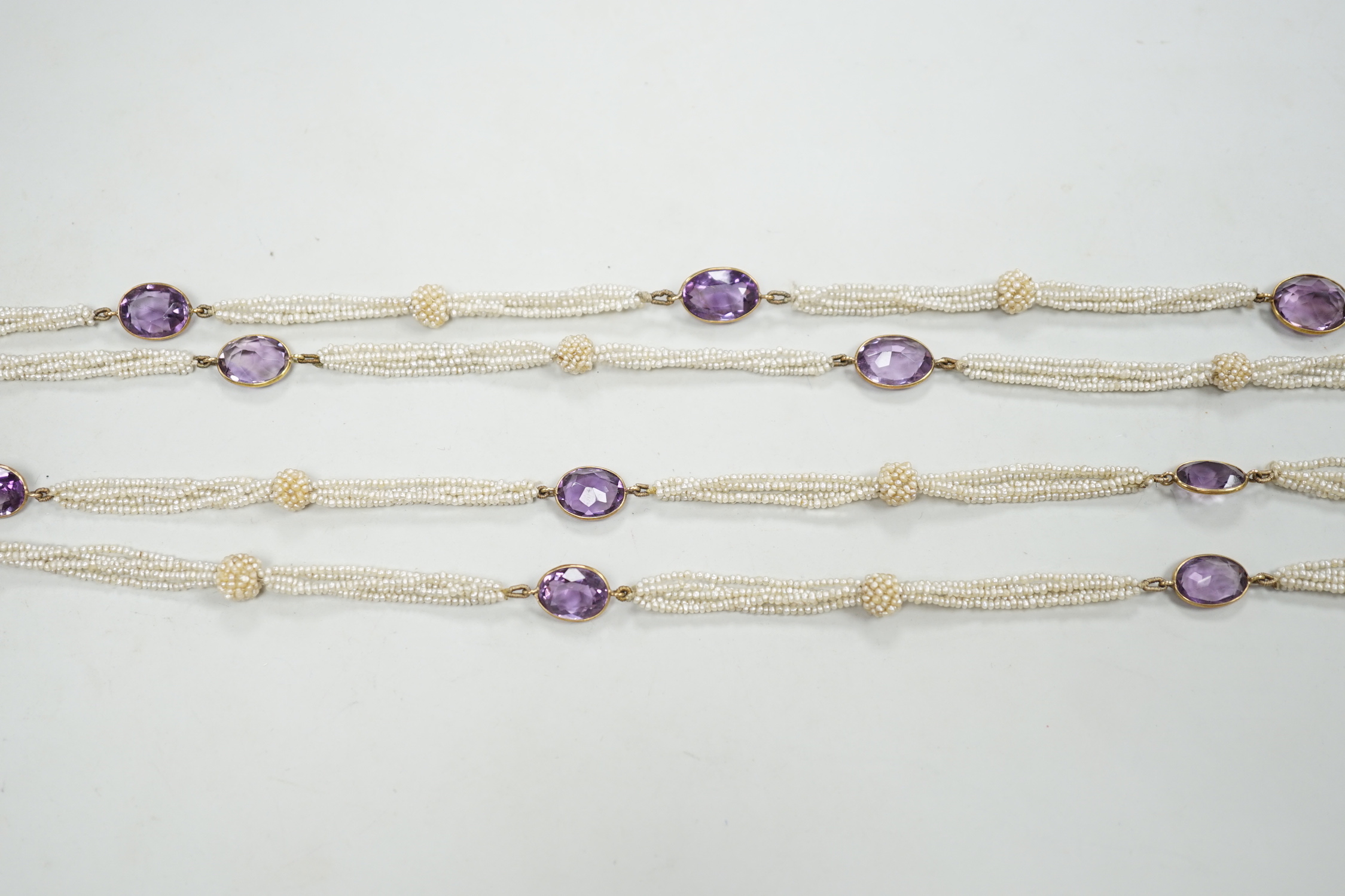 A 19th century Indian multi strand seed pearl and oval cut amethyst set long necklace, with gem set tassel terminals, 170cm.